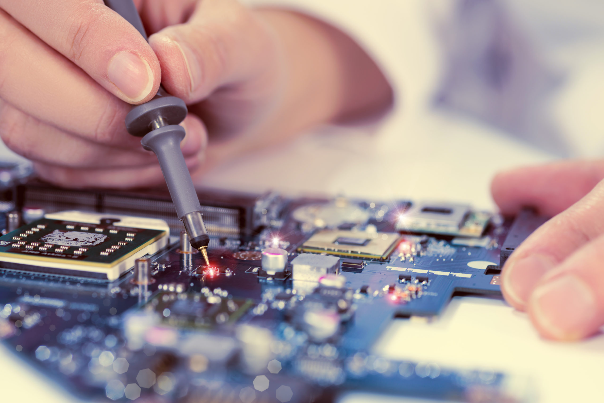 Technological background with closeup on tester checking motherboard.